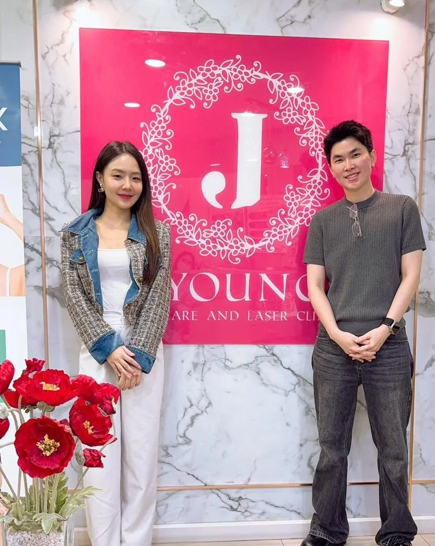 ลูกค้าสองคนถ่ายภาพที่ระลึกคู่กันหน้าป้าย J Young Clinic